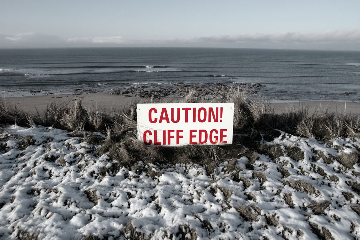 Slippery cliff edge with red caution sign